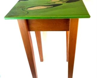 Side table with signed painting of golf course.