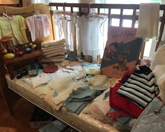 Antique baby clothes, antique breast pump, antique baby shoes and vintage toys