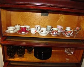 Stack lawyers book case with assortment of cups and saucers