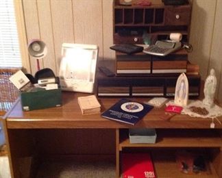 Computer desk, storage drawers, wooden unit with cubbies and two drawers, conair lighted mirror, desk lamp, Nono hair removal system, AT&T and Norte phones, doily, rosaries and Blessed Mother statues