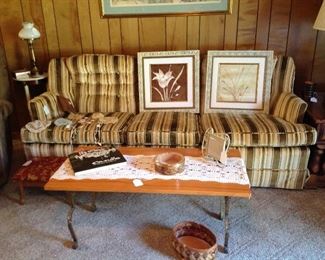 Couch, pair of framed prints, collection of old baby bonnets,  coffee table - iron base with wooden top, Rodriquez book, decorative ashtray, picture frame, basket