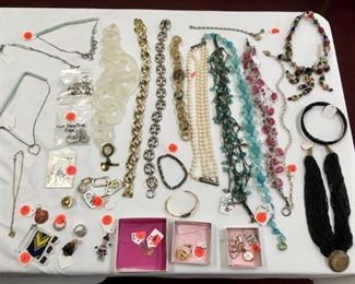 Costume jewelry includes full table of earrings, necklaces, bracelets.
