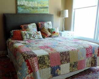 BED WITH FABRIC HEADBOARD AND PATCHWORK QUILT BEDDING
