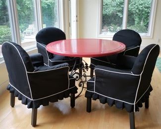 Iron base wooden round red painted top dining table with four slip covered armchairs