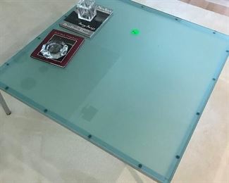 Large glass-top coffee table with metal base.