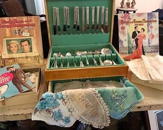 Vintage cutout books, doilys, linens, Crown Silverplate flatware set in box, more