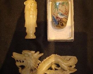 Family Room: A small figure is to the left of a Chinese reverse painted snuff bottle. Below is a soapstone dragon.
