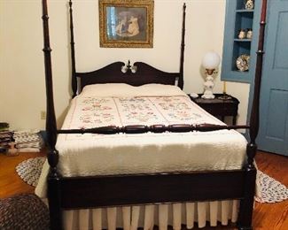 mahogany 4 poster bed with cross stitched quilt and matching bedside table    many rugs
