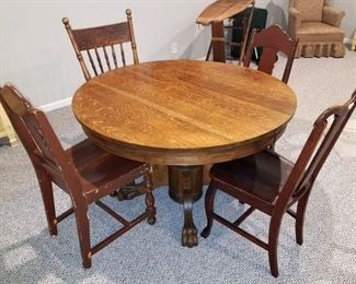 Antique round wood table with leaf. Assorted antique chairs