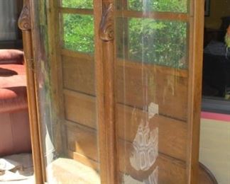 Antique curved front display case.  One piece of glass missing