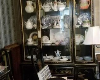 Oriental style china cabinet with many pitchers and plates