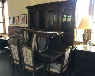Solid wood dining table with six upholstered chairs and glass front china cabinet