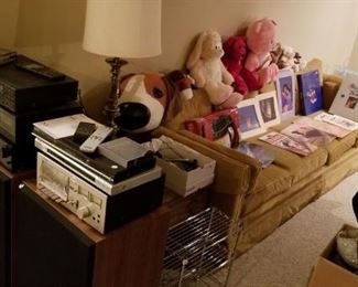 Pioneer audio equipment, Fisher speakers, a long vintage sofa, Disney artwork and some stuffed animals.