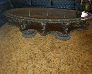 Ornately carved mahogany table with glass table and carved metal feet. 60" x 25" x 17"