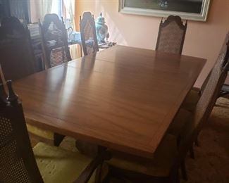 Fabulous vintage yet timeless table is a stately piece for any dining room. Table and chairs in very good condition. Even the woven backs are in great condition. Without the leaf it measures 80'x 44"x 28"