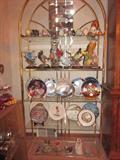 Etegere filled with collectible eggs, wildlife, plates.