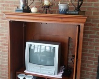 Hooker Furniture entertainment center, 2 metal table lamps (3 total), pottery with handle, pillar holder with glass insert & decor balls, metal filigree candle holder with handle, round tealight holder, small TV with instructions & remote, DVD's & CD's, misc. pillar candle holders