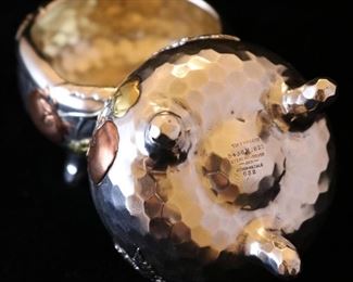 A rare pair of Tiffany antique sterling and mixed metal hammered Japanese style salt cellars with spot hammered surfaces and applied copper details.