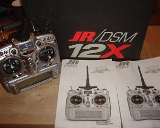 Living Room: A JR DSM 12X 12-channel computer radio system with spektrum 2.4GHz DSM2 technology includes two manuals and its original box. This is the transmitter only and according to the box has: 50-model memory; magnesium transmitter housing; 2048 resolution; extreme low latency; airplane, heli and sailplane software; dual-ink frequency system; multi-link receiver system; flexible switch assignment capacity capability; high resolution, backlit, 5-grey scale screen; rolling selector; model-match model ID system; and servo-sync servo synchronization.