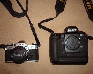 Living Room: A CANON AE-1 camera with 50mm lens; and a NIKON - D1x camera / body only / includes original box / manual & three discs.