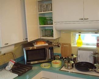 Kitchen: An AMANA commercial microwave model RCS10TS is surrounded by REVERE WARE and CUISINART cookware, glassware, and other kitchen items.