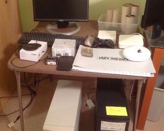 Bedroom #1: an 18" DELL monitor and keyboard are near a Mophie wireless charging base, a Brunton precision transit instrument, and other computer items. A "Van's Aircraft" manual is also shown. Under the table are two hard drives which have been erased.