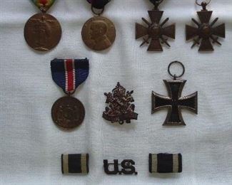 Living Room-Case: Several military related medals are shown, top to bottom: Victory Ribbon/WWI Victory Medal (front: Winged Victory holding a shield and swords, back: "The Great Warrior Civilization"); WWI ribbon and medal: US Army Occupation of Germany; two WWI France War Medals (one with ribbon and one without): Republique Francoise Cross/Swords 1914-1918; State of MO-War with Germany (1917-1919); Deutsche KriegerBund Badge; WWI German Iron Cross 1914/1918 Kaiser Prussian "Army War Award; two black/white ribbons & U.S. pin; and a metal Viet Nam bracelet (09 Jan 1969): Capt. Hugh M Byrd ).