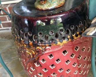 Red, black, green, and gold garden stool