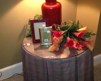 Round side table, frames, flowers, and lamp