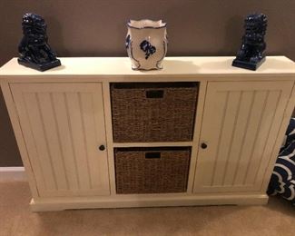 Narrow storage cabinet, also two black ceramic lions protecting a priceless porcelain urn (not priceless)