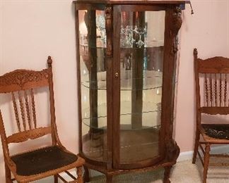 wood/glass curio with glass shelves, two spindle back chairs with leather seat