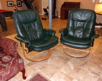 Mid Century Modern leather swivel chairs with ottomans.