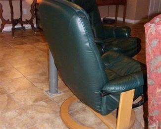 Mid Century Modern leather swivel chairs with ottomans.