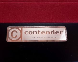 Contender by Brunswick in Graphite laminate/wood/metal with red felt includes pool table accessories such as cues.