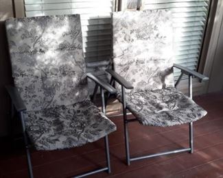 Two very clean foldable lawn chairs.