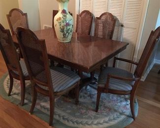Dining table with extra leaf and six chairs.  Nice oval rug, large vase.