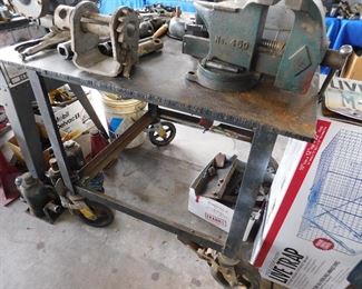 Welding table. 1 inch steel on top, and most interesting, there are three fold down tool hinges. One has a fold up and locking grinder, one has a fold up and locking vise. The third fold up is empty. You can use your tools needed, and then fold them down and out of your way with this table. An absolutely great idea.