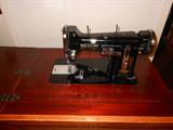 Vintage Necchi Sewing Machine in Cabinet. Cabinet has inset chair.