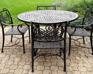 Five piece patio set has 5' round table & four arm chairs