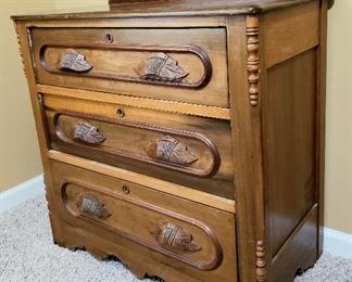 Three drawer antique chest has carved pulls