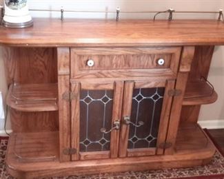 Oak entry/sofa table with lead design glass doors and rail accent