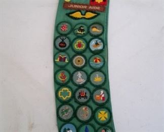 Girl Scout sash with badges, pins.