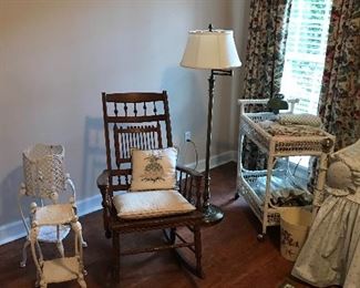 Antique rocker, cast iron plant stands, and wicker cart