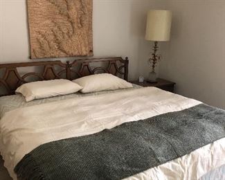 king headboard and nightstand - brass and glass lamp and macramé artwork