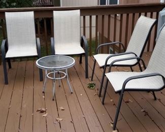 Four patio chairs and one glass top side table.