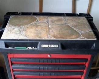 Craftsman tool chest with casters, peg boards on the side and added ceramic tile on top.