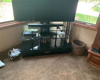 Tv stand holds up to 70” TV. Glass shelves and a drawer. 