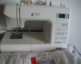 Kenmore sewing maching.  There is a lot of sewing supplies, thread, trims, ribbons, needles, buttons, pins and a "full" sewing stand.  