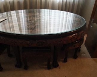 glass top, wood carved coffee table with 6 foot stools