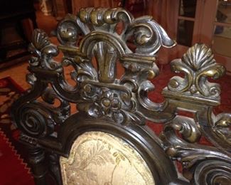 The matching chairs have detailed carving.